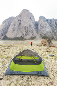 Climber set up camp under a stunning granite tower in akshayak pass