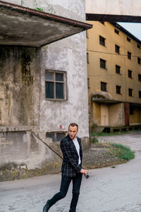Full length of man standing on street against building in city