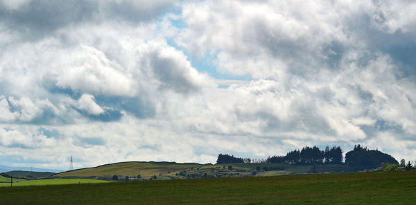 Scenic view of grassy field against cloudy sky
