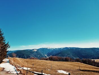 Scenic view of snowcapped mountains against blue sky