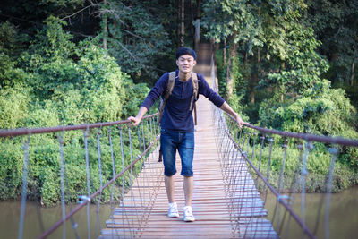 Full length of man standing on footbridge