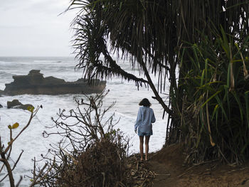 Young woman walking at ocean coastline