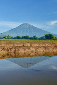 Scenic view of landscape and mountains against blue sky