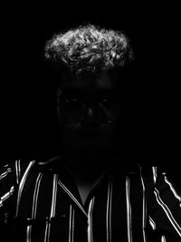 Close-up portrait of young man against black background