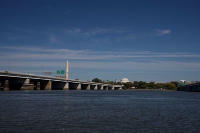 Bridge over river against cloudy sky