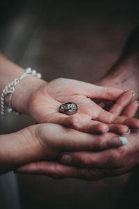 Close-up of couple hands holding rings