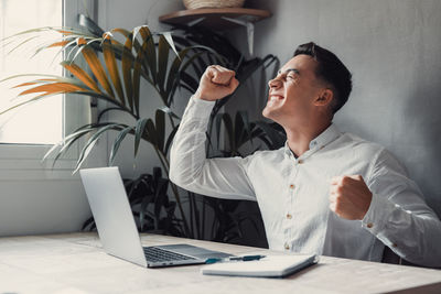 Side view of businessman using laptop on table