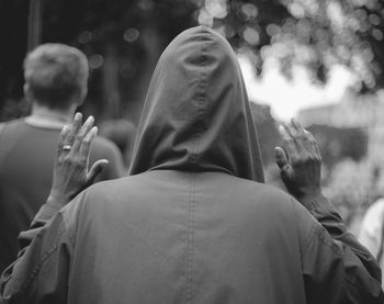 Rear view of man gesturing outdoors