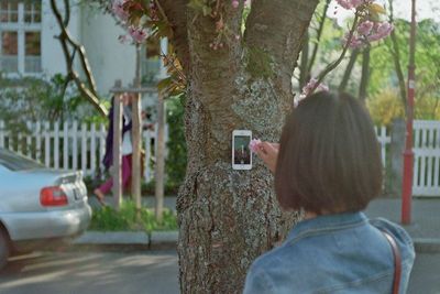 Woman standing on tree trunk