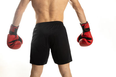 Midsection of shirtless man standing against white background