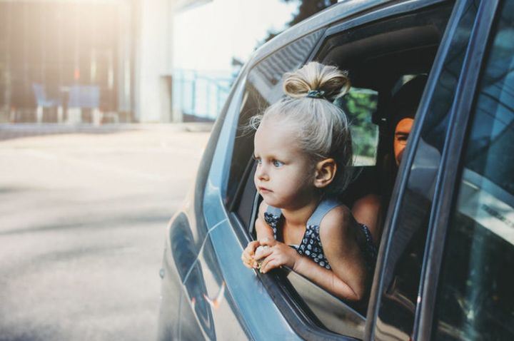 PORTRAIT OF HAPPY GIRL IN CAR