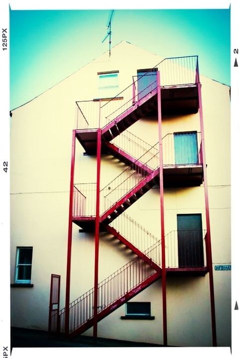 architecture, built structure, railing, building exterior, low angle view, staircase, steps, steps and staircases, transfer print, balcony, building, auto post production filter, day, window, sunlight, residential building, no people, clear sky, blue, residential structure