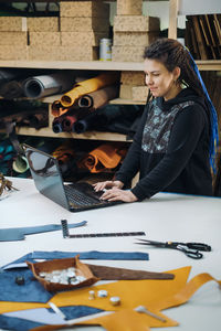 Online ordering tailoring from seamstress. young woman business owner looking at laptop screen 