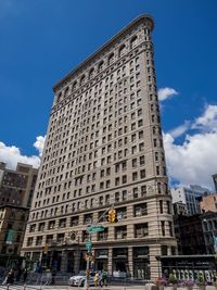 Low angle view of flatiron building and towers against sky