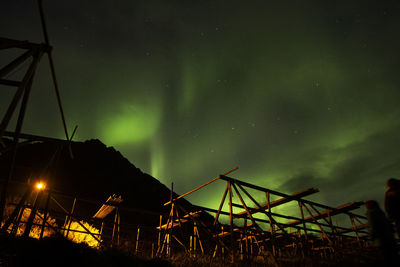 Low angle view of illuminated built structure against sky at night