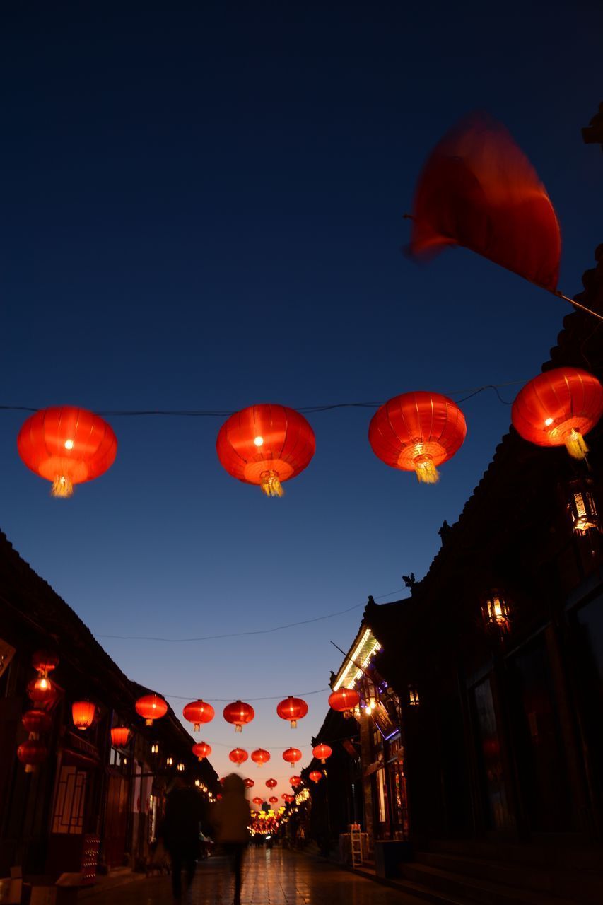 LOW ANGLE VIEW OF LANTERNS HANGING AGAINST SKY AT NIGHT