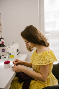 Side view of a woman sitting at home