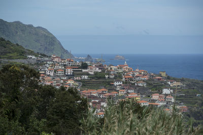 High angle view of townscape by sea against sky