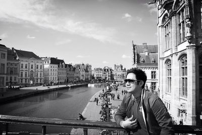 Buildings in city against cloudy sky