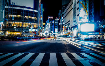 Light trails on road along buildings at night