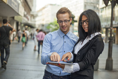 Young man using smart phone in city