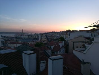 Houses in town against sky during sunset