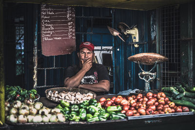 Farmer selling vegetables at market stall