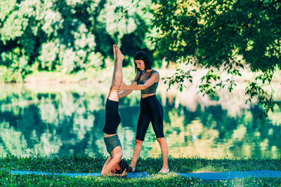 Yoga woman by the water. headstand pose