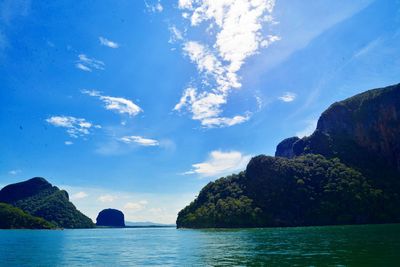 Scenic view of sea and mountains against blue sky