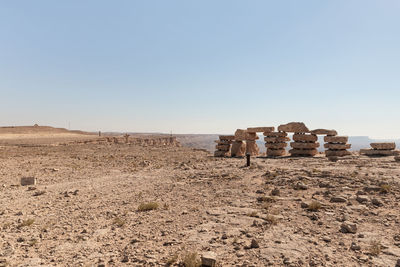 Group of people on arid landscape against clear sky