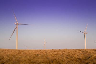 Windmill on field against clear sky
