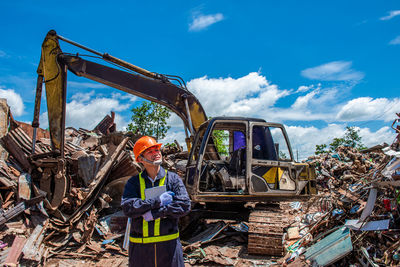 Low angle view of man holding construction site against sky