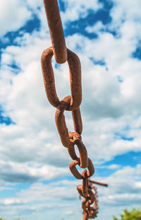 Old rusty chain on the field on background of the sky