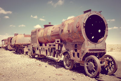 Abandoned train on land against sky