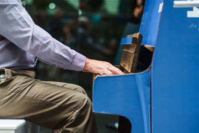 Midsection of man playing piano