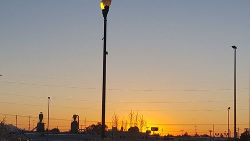 Illuminated city against sky during sunset