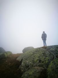 Rear view of man looking at mountain against sky