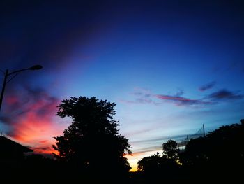 Low angle view of silhouette trees against sky at sunset