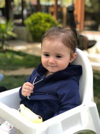 Portrait of cute boy sitting outdoors