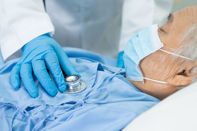 Midsection of doctor examining patient in hospital