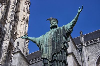 Low angle view of statues on building against sky