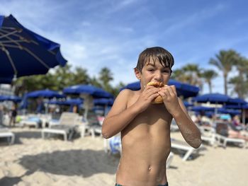 Side view of young man holding umbrella