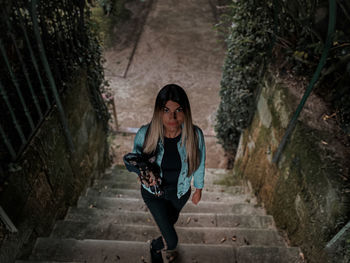 Portrait of young woman standing against wall