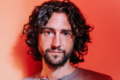 Portrait of young man against red background