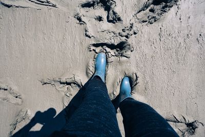 Low section of person standing on mud