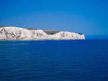 Scenic view of sea against clear blue sky