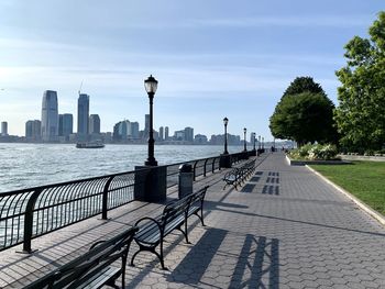 Street by river and buildings against sky