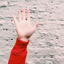 Close-up of woman hand against wall