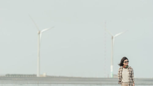 Woman with umbrella against sky