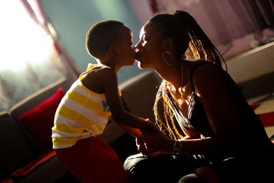 Boy kissing mother at home